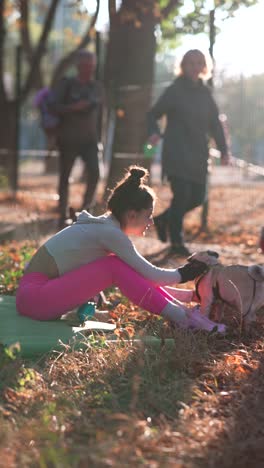 woman exercising outdoors with a pug in autumn park