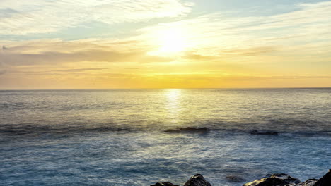 Vibrant-coastal-sunrise-with-golden-horizon,-dynamic-ocean