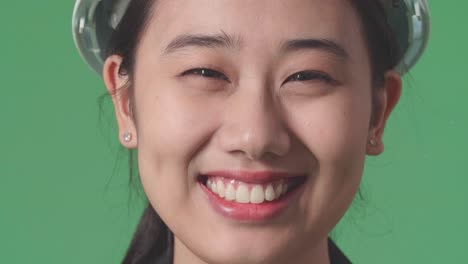 smiling asian woman in construction helmet