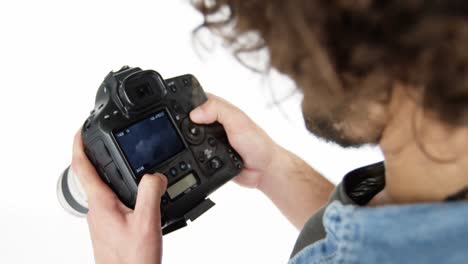 Photographer-looking-at-photos-on-digital-camera