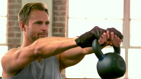 fit man doing kettlebell swings