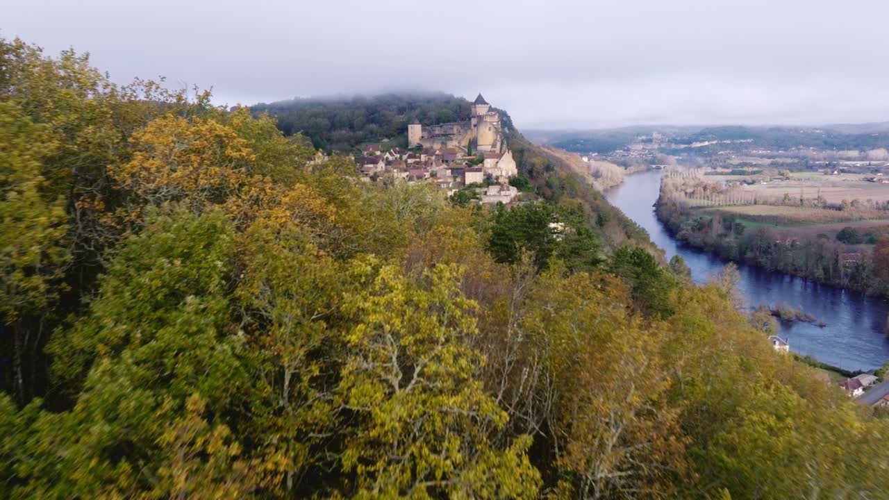 Mist over the chateau of Castelnaud la chapelle in the Dordogne, river and bridge above.
