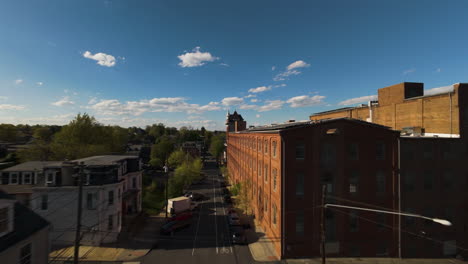 aerial fpv over american town with solar panels on roof on top of red brick facade