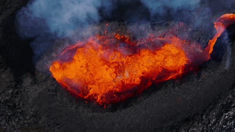 abajo de la parte superior del cráter del volcán expulsando lava fundida caliente, explosión de fuego