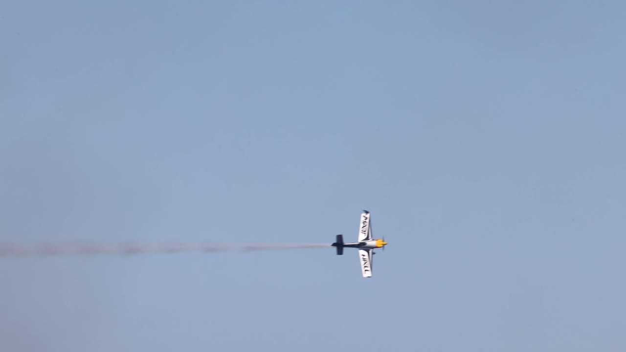 одиночный самолет, выполняющий воздушные маневры с дымовым следом