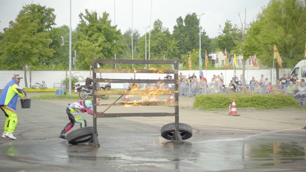 Man Lit Up Wooden Barrier With Fire For A Stunt Show Exhibition. wide shot