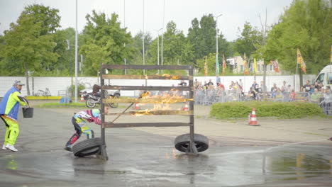 man lit up wooden barrier with fire for a stunt show exhibition. wide shot