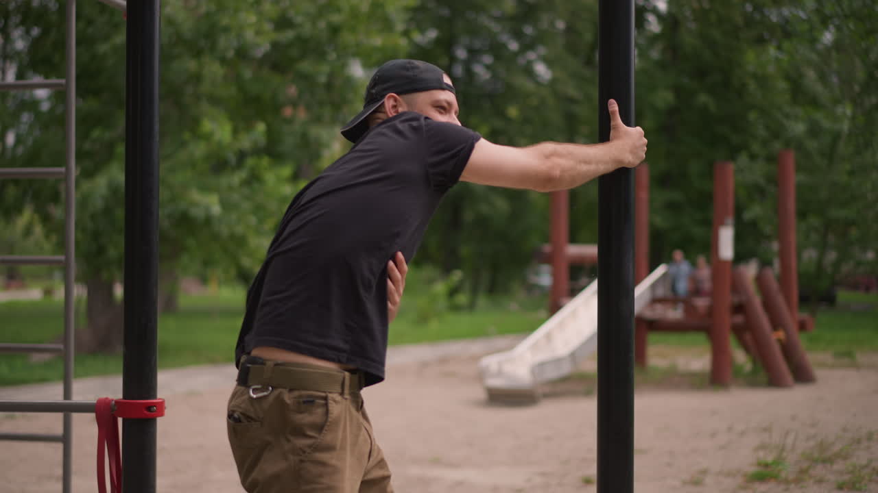 Person Taking Break In Tranquil Park, Worker Leans On Pole Relaxing After Completing Task Peacefully, Individual Resting On Pole Feeling Relieved And Calm In Peaceful Outdoor Environment