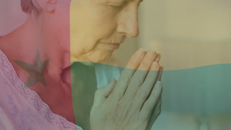 praying, elderly woman over ghana flag animation, expressing hope and faith