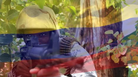 Digital-composition-of-waving-colombia-flag-against-soldier-training-with-a-gun-at-training-camp