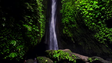 scenic leke leke waterfall plunges through leafy foliage on cliff in bali jungle