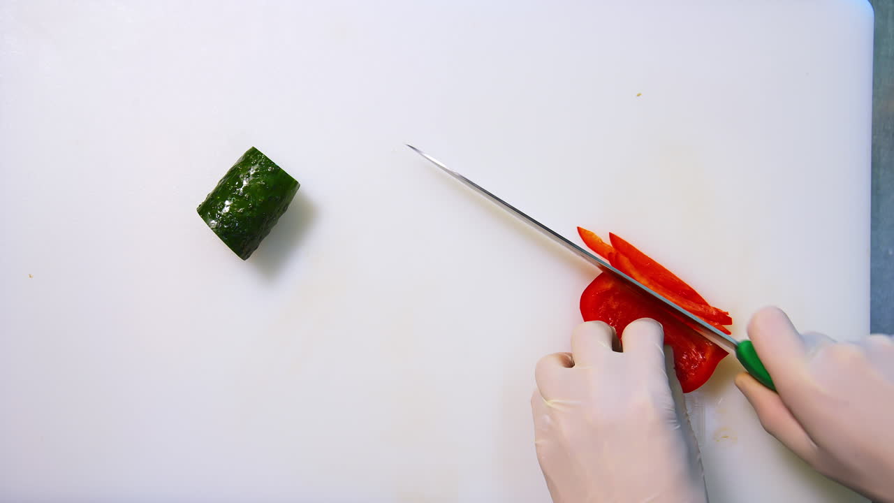 Chef hands slicing sweet red bell pepper on a white cutting board. Beautiful video with soft focus. Healthy food concept.