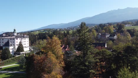 aerial view of ambras historical castle showing the alps on a sunny autumn day, with the forests on the hills full of calm, green hills, innsbruck,tyrol,austria,europe