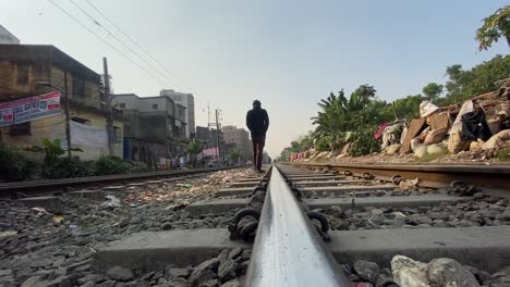 Lonely-Man-Walking-On-Railway-Track-Into-Horizon