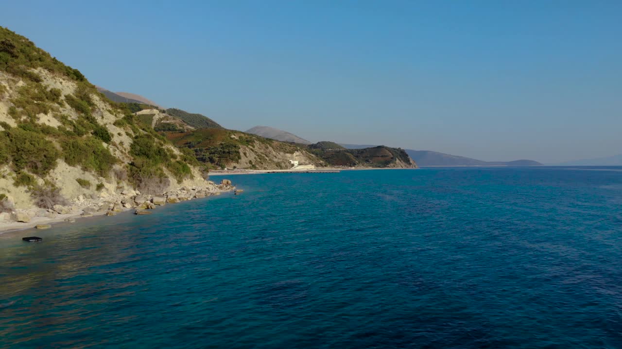 Blue azure sea water washing rocky shoreline down the hills on a sunny day in Mediterranean