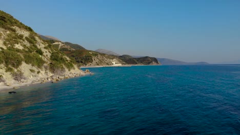 Blaues-Azurblaues-Meerwasser,-Das-An-Einem-Sonnigen-Tag-Im-Mittelmeer-Felsige-Küstenlinie-Die-Hügel-Hinunterspült