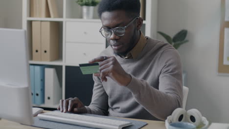african american man paying online with credit card