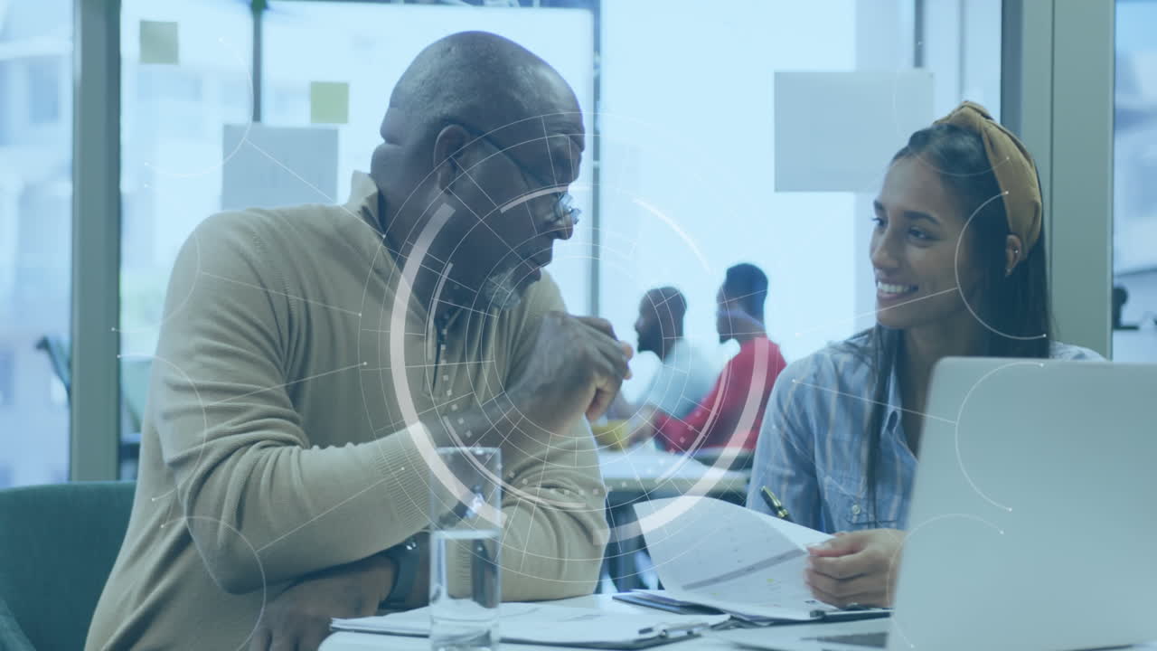 Animation of round scanner over diverse man and woman discussing over documents at office