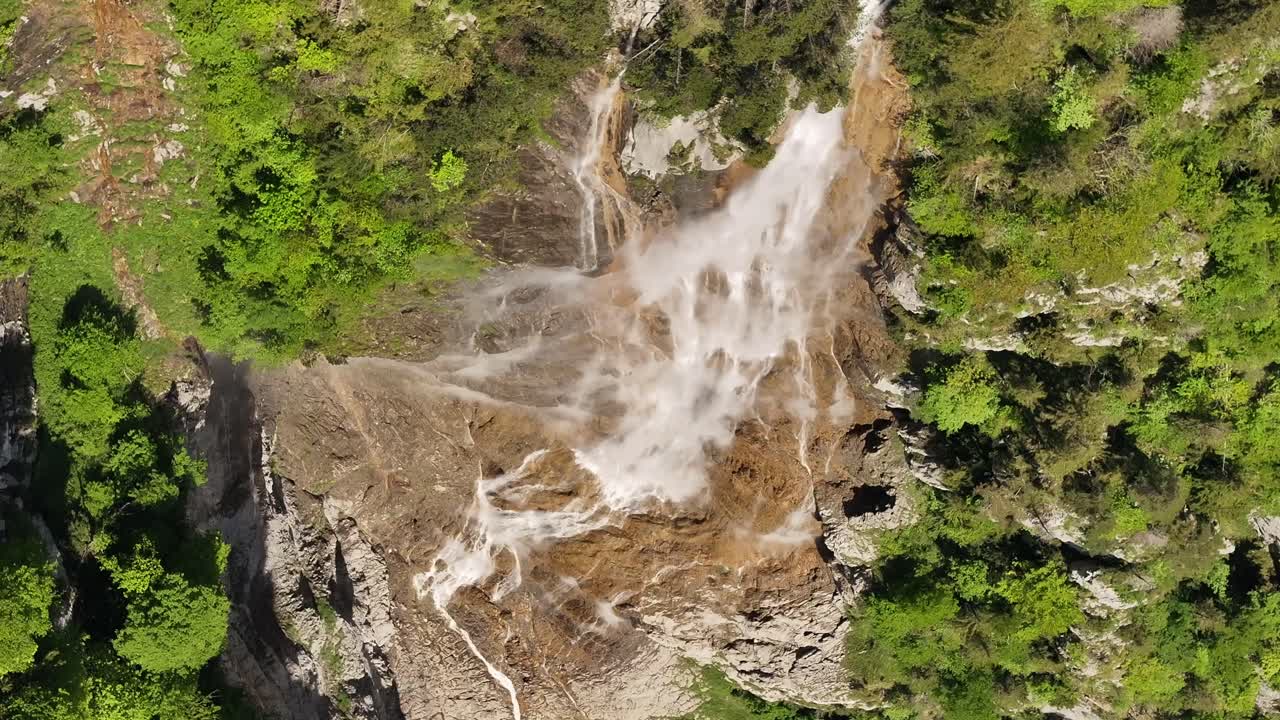Aerial top-down view of Seerenbach Falls in Betlis, Switzerland, waterfall flows through forest and rocky cliffs