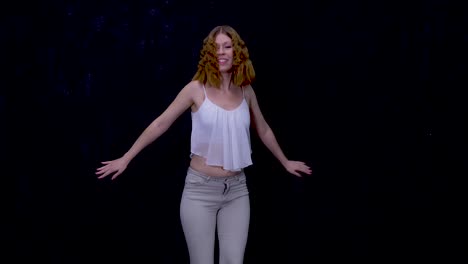 caucasian female dancing alone in studio with black background, medium shot