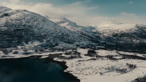 winter snow mountain ridge over the fishing village of lodingen in nordland county, norway. aerial shot
