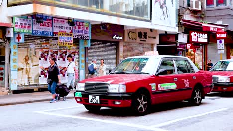 people and taxis on a bustling hong kong street