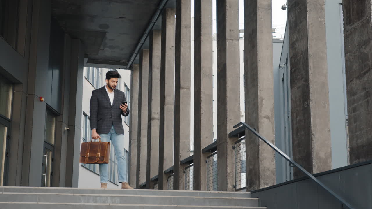 uomo d'affari che usa lo smartphone sulle scale
