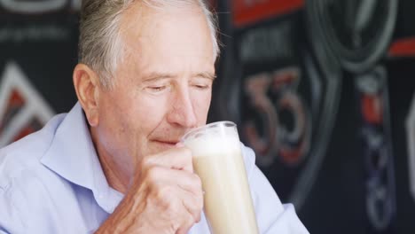 senior man having milkshake in cafe 4k