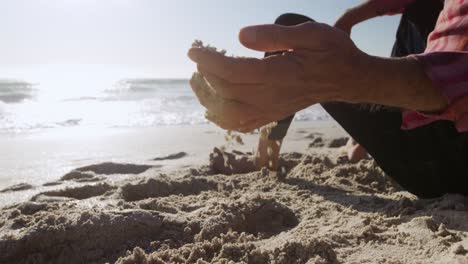 senior man touching the sand