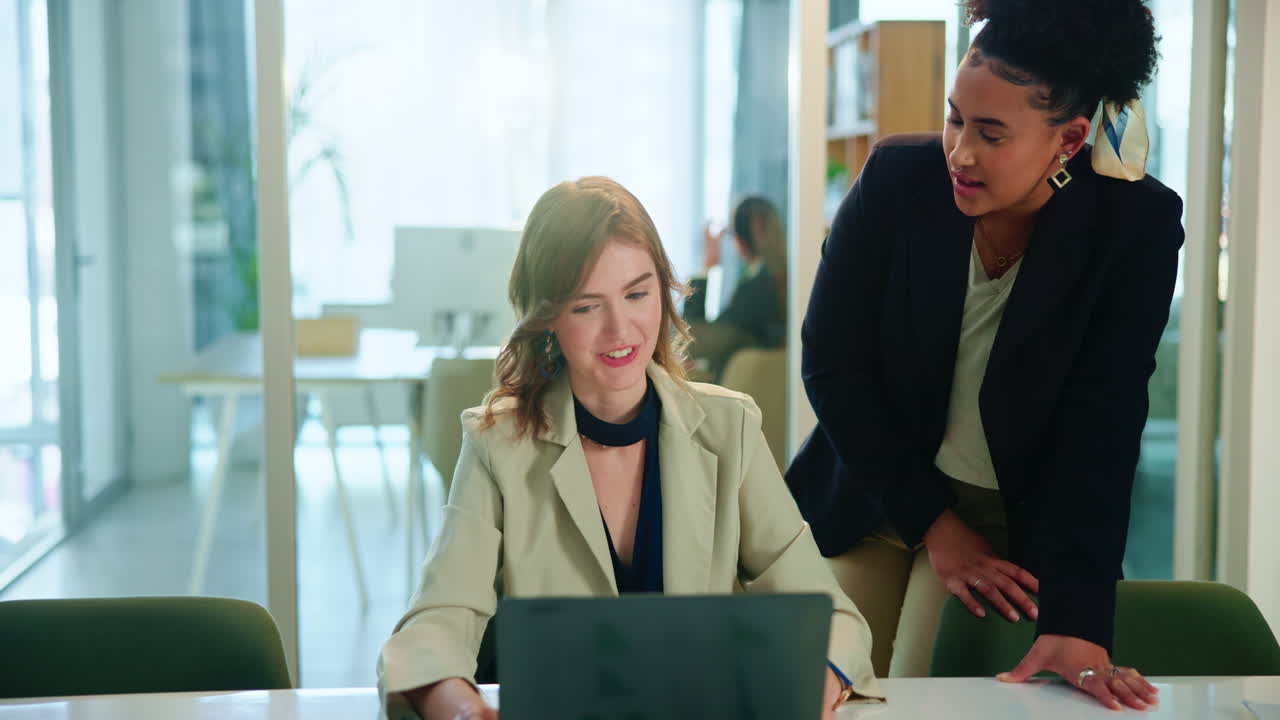 Two Businesswomen Collaborate on a Project in a Modern Office