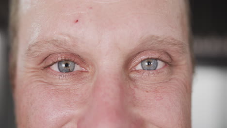 Portrait-close-up-of-blue-eyes-of-happy-caucasian-male-chef-in-smiling-in-kitchen,-slow-motion