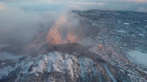 drohnen-aufnahme des bergen-gebirges mit blick auf die stadt bei sonnenuntergang, norwegen