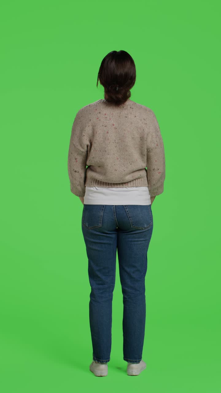 Video verticale: modello arrabbiato visto da dietro che si mostra frustrato a figura intera su green screen