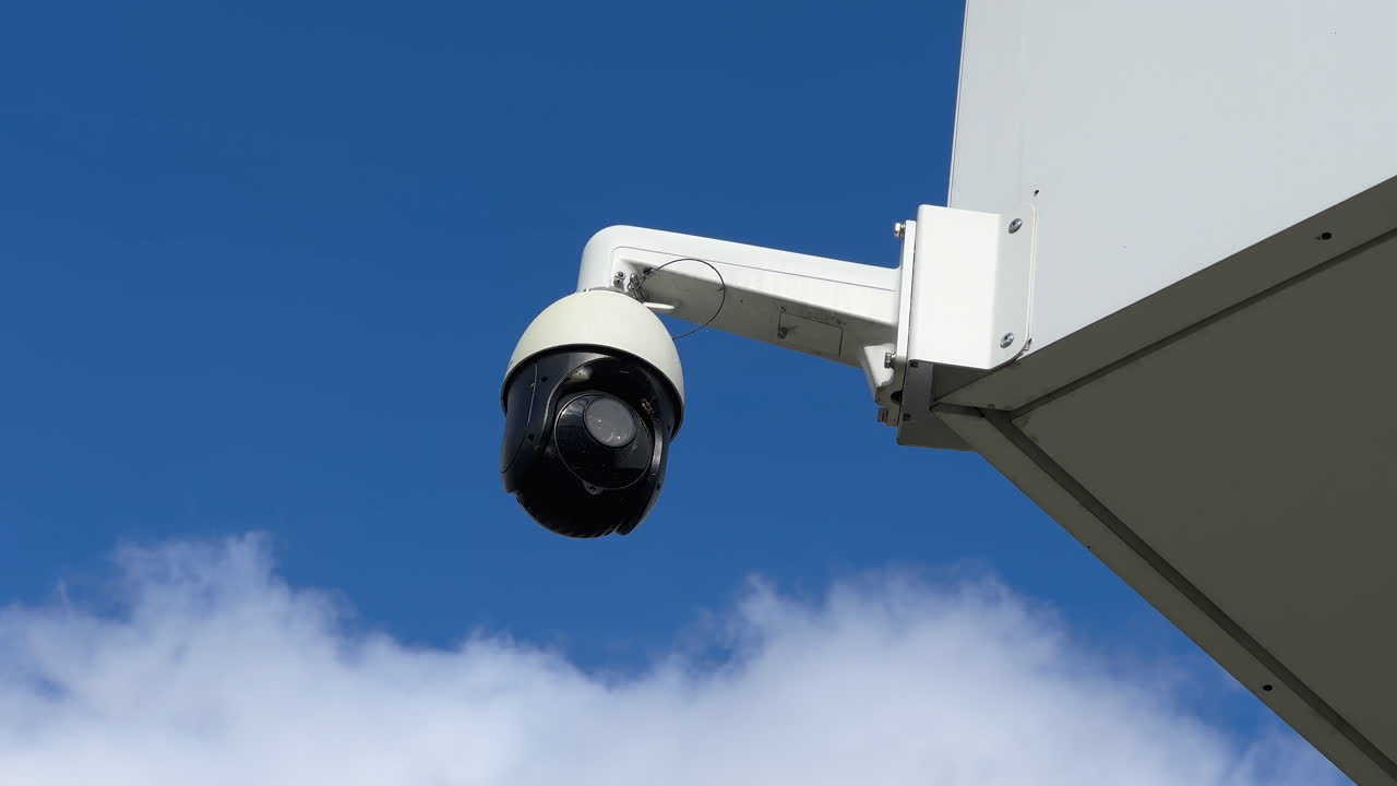 cámara de vigilancia moderna montada en un edificio contra un cielo azul