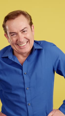 joyful man laughing heartily against a yellow background
