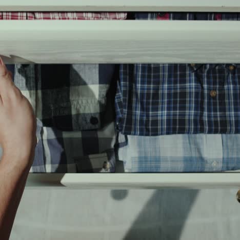 Man-opens-drawer-with-shirts-1