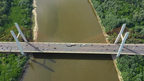 Aerial-or-top-view-from-drone-of-concrete-bridge-with-asphalt-road-or-highway-over-big-river-with-city-car-traffic,-urban-transportation,-toned