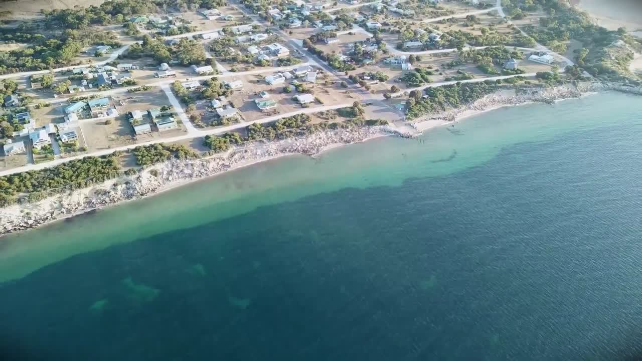 Vista aérea do mar e do oceano, capturando ondas agitadas e vasta água azul vista de cima. Ideal para filmes de viagem, cenas cinematográficas, projetos costeiros, temas marinhos e fundos de natureza cênicos.
