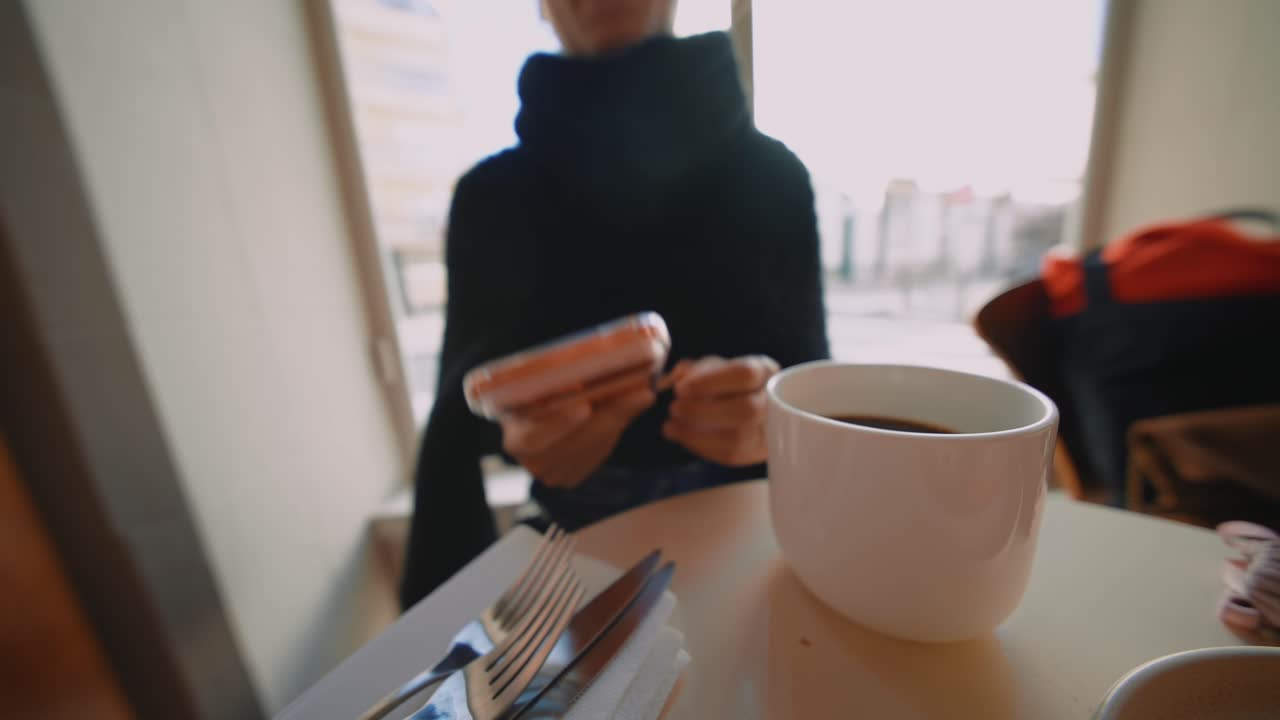 Person using smartphone with coffee