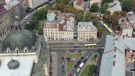 bandera de ucrania ondeando en la parte superior del teatro académico nacional de ópera y ballet de lviv con autos sentados en el tráfico en la carretera