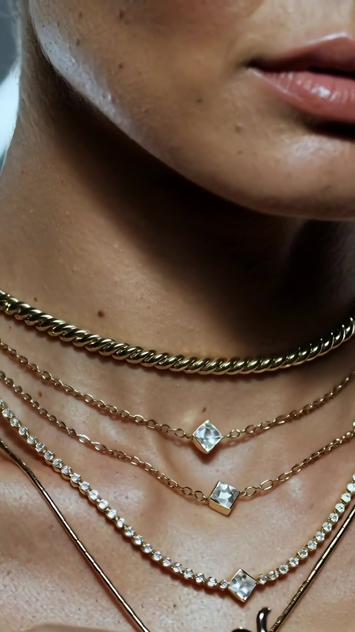 Video verticale: Una donna si gira e sistema con il dito catene d'oro sovrapposte per posizionarle in studio.
