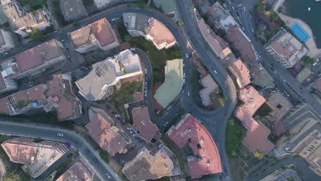 aerial top down overhead footage of cars driving on different sections of a hill in a suburb of naples, italy