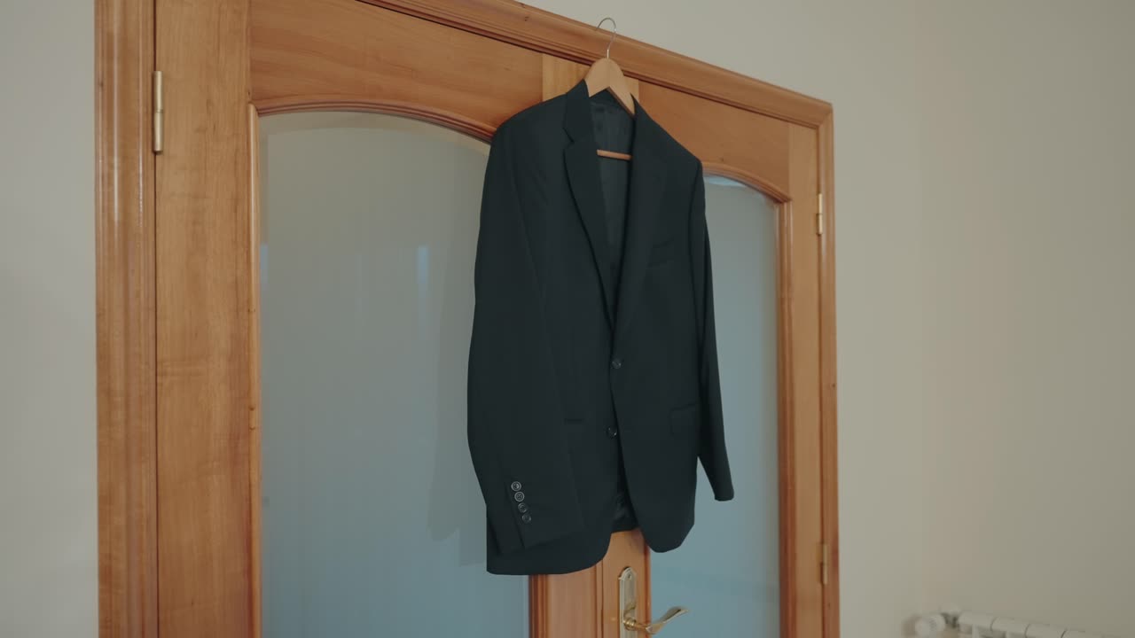 Giacca da abito formale appesa a una gruccia su una porta interna in legno