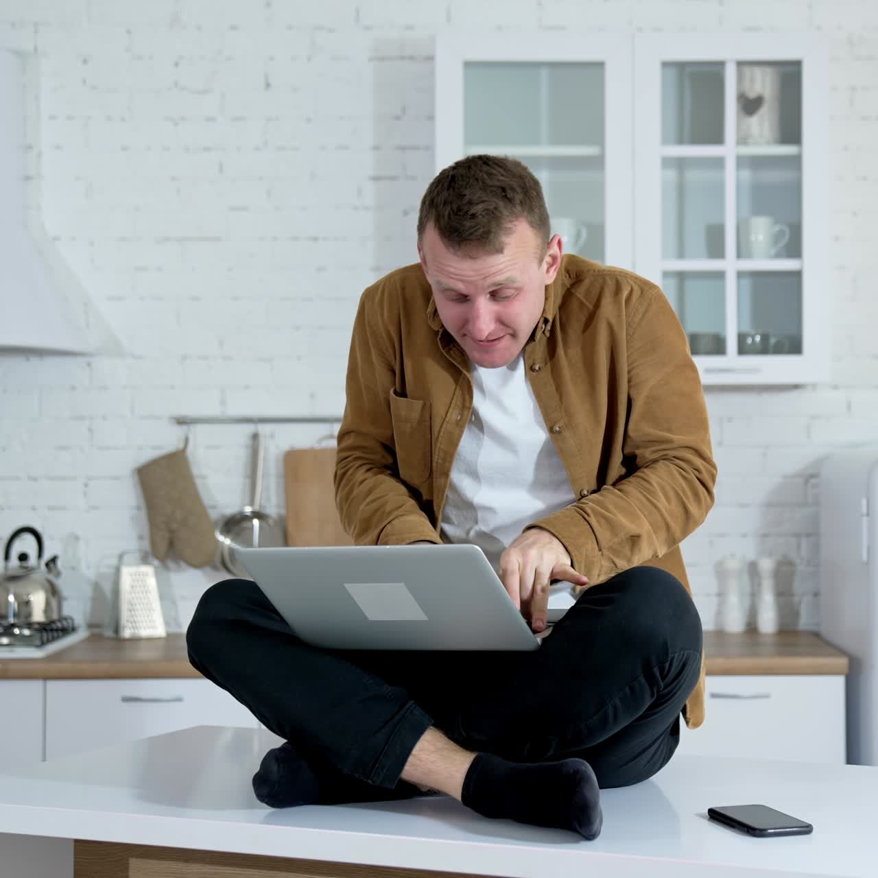 Man typing on laptop. Crazy man using laptop sitting on the table at home