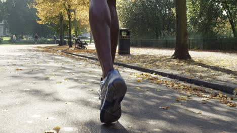 Cerrar-Pies-Grupo-De-Corredores-Corriendo-En-El-Parque-Usando-Dispositivos-Conectados-A-Tecnología-Portátil