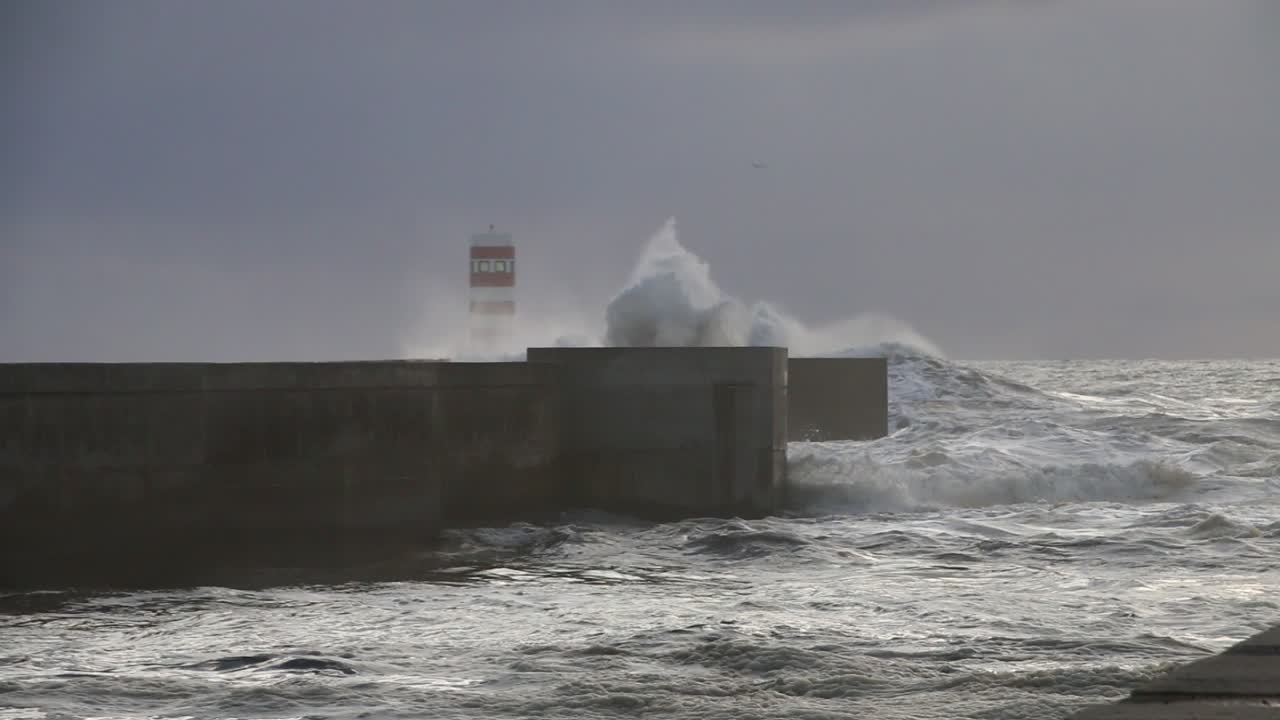 파도가 추운 구름과 바람이 불는 저녁에 포르토의 등대를 짓 ⁇ 고 있습니다.