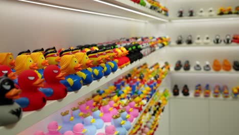 Young-woman-shopper-browsing-rows-of-colourful-rubber-ducks,-slow-motion