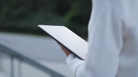 Shot-from-behind-of-a-businesswoman-browsing-on-her-tablet