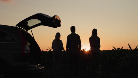 family with a child admiring the sunset in the countryside