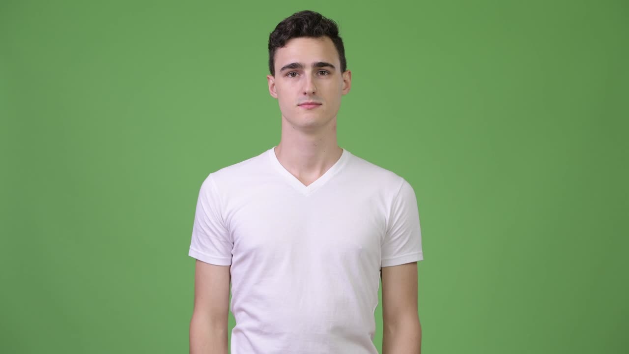 Young handsome man shrugging shoulders